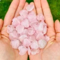 Mini pink rose quartz hearts held in a hand