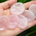 Oval rose quartz worry stones held in a hand