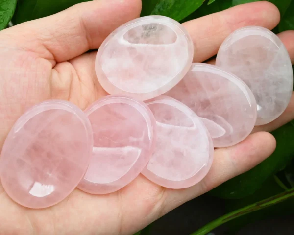Oval rose quartz worry stones held in a hand Oval rose quartz worry stones held in a hand