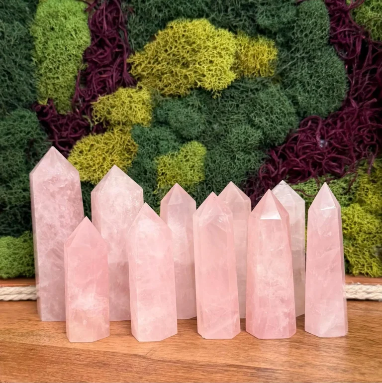 A selection of rose quartz towers arranged together on a wooden surface